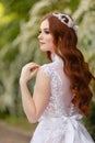 Beautiful redhead Bride in fantastic wedding dress in blooming garden. Royalty Free Stock Photo