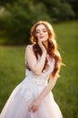 Beautiful redhead Bride in fantastic wedding dress in blooming garden. Royalty Free Stock Photo