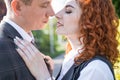 Beautiful redhead couple touching each other with noses in nature. Royalty Free Stock Photo