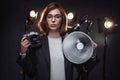 Beautiful redhead female photographer holds a digital camera and looking on the camera Royalty Free Stock Photo