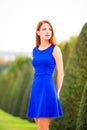 Beautiful redhead girl in blue dress in Versailles park Royalty Free Stock Photo