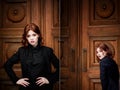 Beautiful redhead girl with plump lips on a background of textured brown door. In a dark suit. Sensual. Ginger