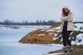 Beautiful redhead girl stays against Nordic landscape