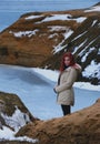 Beautiful redhead girl stays against Nordic landscape