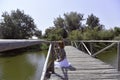 Redhead girl staying on a wooden dock above Danube river near trees. Royalty Free Stock Photo