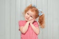 Beautiful redhead little girl touching face, looking at something adorable, contemplating cute thing, smiling happy Royalty Free Stock Photo