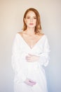 Beautiful redhead pregnant woman in white dress