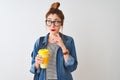 Beautiful redhead student woman drinking take away coffee over isolated white background serious face thinking about question,