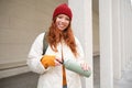 Beautiful redhead woman drinking hot tea or coffee from thermos, female tourist enjoys warm drink, rests during her Royalty Free Stock Photo