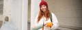 Beautiful redhead woman drinking hot tea or coffee from thermos, female tourist enjoys warm drink, rests during her Royalty Free Stock Photo