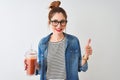 Beautiful redhead woman drinking smoothie of tomato over isolated white background happy with big smile doing ok sign, thumb up Royalty Free Stock Photo