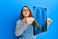 Beautiful redhead woman holding chest radiography looking at the camera blowing a kiss being lovely and sexy