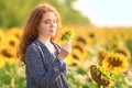 Beautiful redhead woman in sunflower field on sunny day Royalty Free Stock Photo