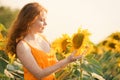 Beautiful redhead woman in sunflower field on sunny day Royalty Free Stock Photo