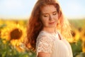 Beautiful redhead woman in sunflower field on sunny day Royalty Free Stock Photo