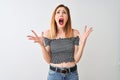 Beautiful redhead woman wearing casual t-shirt standing over isolated white background crazy and mad shouting and yelling with Royalty Free Stock Photo