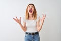 Beautiful redhead woman wearing casual t-shirt standing over isolated white background crazy and mad shouting and yelling with