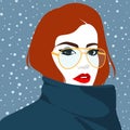 Beautiful redhead woman wearing the golden glasses and dark blue coat against winter snowing background