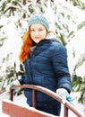 Beautiful Redhead Young Woman Stands Next To Bench In A Snowy Park