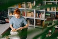 Beautiful redhead young woman student is reading book enjoys of rest at home office. Royalty Free Stock Photo