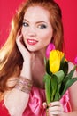 Beautiful redheaded girl is holding tulips Royalty Free Stock Photo