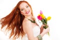 Beautiful redheaded girl is holding tulips Royalty Free Stock Photo