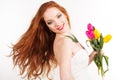Beautiful redheaded girl is holding tulips Royalty Free Stock Photo