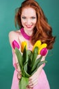 Beautiful redheaded girl is holding tulips Royalty Free Stock Photo