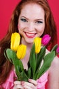 Beautiful redheaded girl is holding tulips Royalty Free Stock Photo