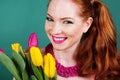 Beautiful redheaded girl is holding tulips Royalty Free Stock Photo