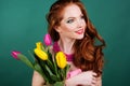 Beautiful redheaded girl is holding tulips, spring Royalty Free Stock Photo