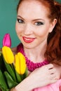 Beautiful redheaded girl is holding yellow tulips Royalty Free Stock Photo