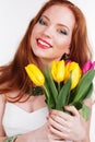 Beautiful redheaded happy girl is holding tulips Royalty Free Stock Photo