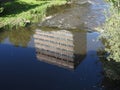 Beautiful reflection mirror building in running water, flow and river. Shutter high speed photograpy. Blue and grey. Art.