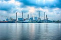 Beautiful reflection of Oil refineries located along the river with dark clouds background-Image Royalty Free Stock Photo