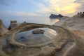 Beautiful reflection of rosy sunrise sky at Yehliu Coast Geologic Park with candlestick rock formations