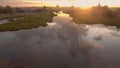 Beautiful reflection of sky in river passing through village. Stock footage. Top view of panorama of Russian town in