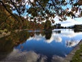 Lovely lake with blue sky and clouds reflection and small center island. Royalty Free Stock Photo