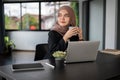 A relaxed Asian Muslim businesswoman is daydreaming while having her morning coffee at her desk Royalty Free Stock Photo