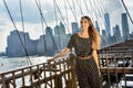 Beautiful relaxed blonde young woman wearing fashionable clothes, posing on the Brooklyn Bridge.