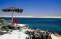 Beautiful relaxing tropical desert sea lagoon landscape, two red empty isolated chairs, palapa tiki thatch umbrella, white sand Royalty Free Stock Photo