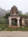 Beautiful religious landmark of Veerabhadreshwara Swamy Temple with light, tower and huge stone hill and public Royalty Free Stock Photo