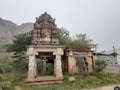 Beautiful religious landmark of Veerabhadreshwara Swamy Temple with light, tower and huge stone hill and public Royalty Free Stock Photo