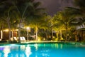 Resort hotel pool at night with lights and palm trees i Royalty Free Stock Photo