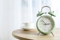 Beautiful retro alarm clock with cup of coffee on table Royalty Free Stock Photo