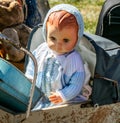 Beautiful retro baby doll in baby carriage at flea market