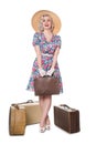 Beautiful retro blond standing with vintage suitcases, wearing s