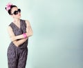 Beautiful retro girl in sunglasses with a bow on his head is in the Studio on a blue background Royalty Free Stock Photo