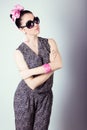 Beautiful retro girl in sunglasses with a bow on his head is in the Studio on a blue background Royalty Free Stock Photo