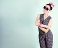 Beautiful retro girl in sunglasses with a bow on his head is in the Studio on a blue background Royalty Free Stock Photo